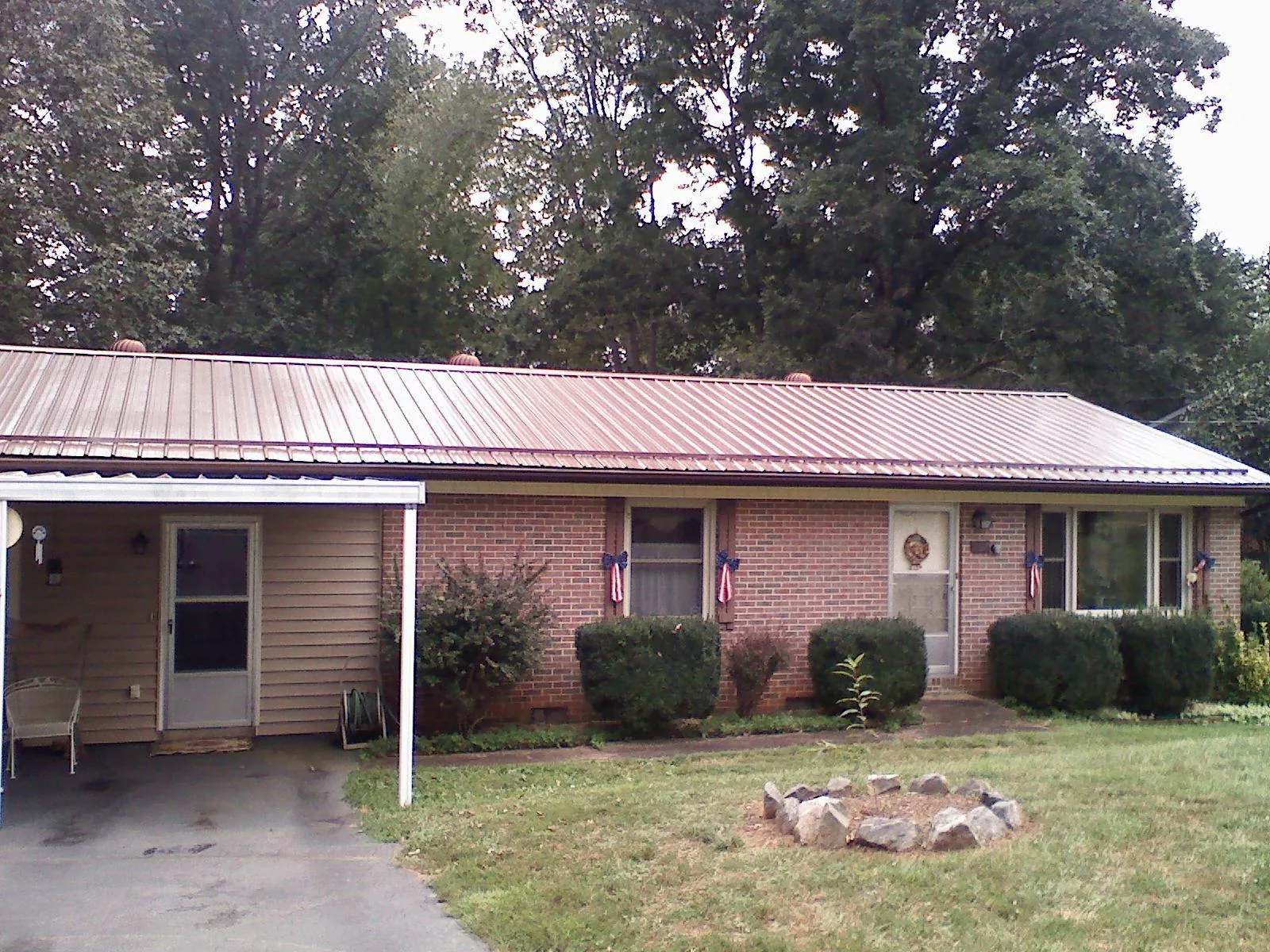 Bronze metal roof and carport on a brick ranch home — Roof Repair work by our crew in Wading River
